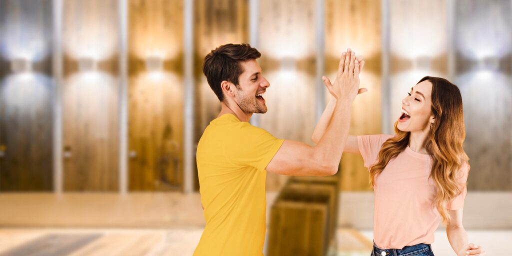 BESTPREIS-GARANTIE: Freudiges Paar gibt sich in der Parkett-Ausstellung ein High-Five